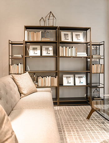 A stylish modern living room featuring bookshelves with decor and a comfortable sofa. Ideal for interior design inspiration. HD phone wallpaper