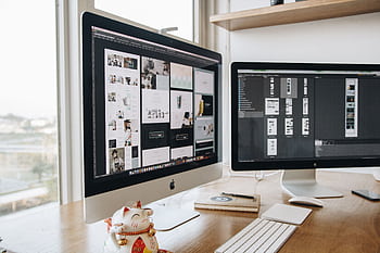 A stylish workspace featuring dual monitors and a lucky cat figurine, ideal for technology and design themes. HD wallpaper