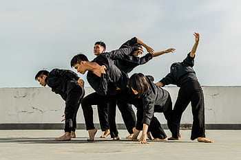 A group of adults performing dynamic contemporary dance on a rooftop. HD wallpaper
