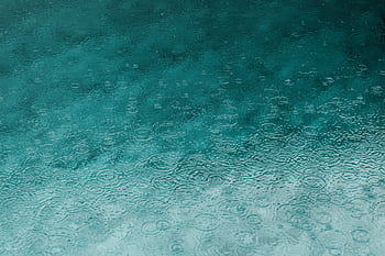 Serene teal water surface with ripples and raindrops, perfect for backgrounds. HD wallpaper