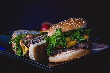 Delicious cheeseburger with lettuce and tomato served on a dark plate. HD wallpaper