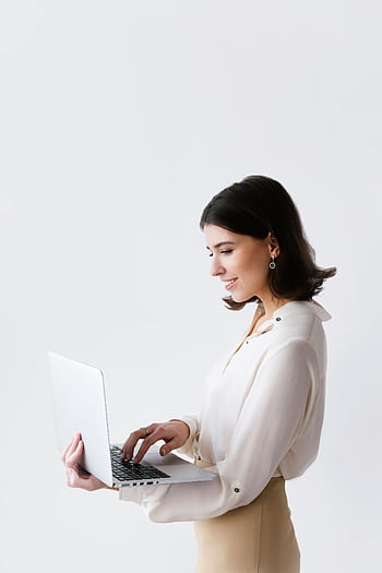 Side view of a businesswoman typing on a laptop against a white background in a studio. HD phone wallpaper