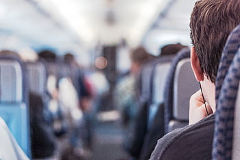 Blurred view of passengers seated on a train, emphasizing travel experience. HD wallpaper