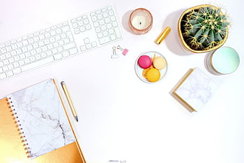 Minimalist office desk setup with cactus, keyboard, and colorful macarons for a modern aesthetic. HD wallpaper