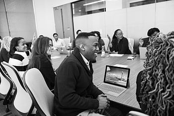 Business professionals engaged in a collaborative meeting in a modern office setting. HD wallpaper