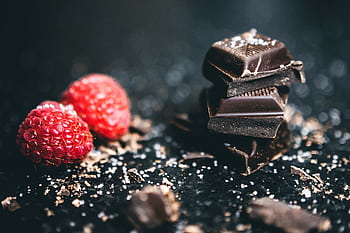 Close-up of dark chocolate pieces and raspberries, perfect for gourmet dessert ideas. HD wallpaper