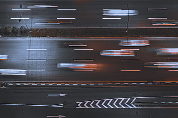 Blurred night traffic on highway, captured from above, showcasing urban speed and motion. HD wallpaper