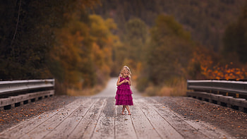 Cute Little Girl Is Standing On Wood Dock Wearing Purple Dress In Blur Colorful Autumn Trees Background Cute HD wallpaper