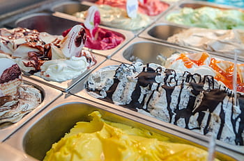 Close-up of various gelato flavors in a parlor display, perfect for dessert enthusiasts. HD wallpaper