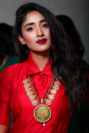 Portrait of a young woman in traditional attire with elegant jewelry and a confident pose. HD phone wallpaper