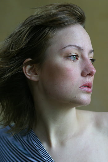 A young woman looks thoughtfully into the distance, capturing emotions with a side profile view. HD phone wallpaper