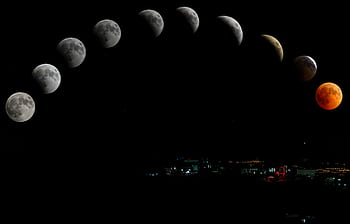Captivating lunar eclipse sequence featuring blood moon over cityscape. HD wallpaper
