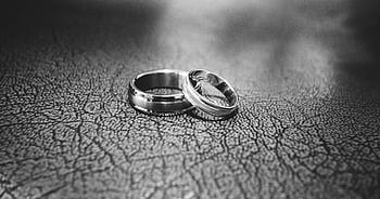 Elegant black and white close-up of wedding rings symbolizing love and commitment. HD wallpaper
