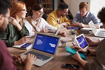 A diverse group of professionals having a collaborative meeting in a modern office setting. HD wallpaper
