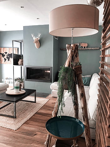 Elegant modern living room featuring natural wood accents, lush green plants, and a unique rustic lamp. HD phone wallpaper