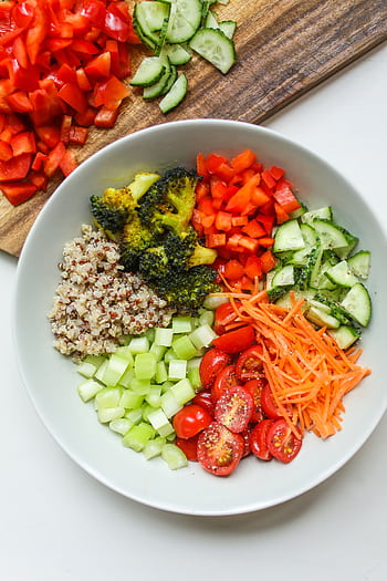 A vibrant bowl of fresh vegetables and quinoa, perfect for a healthy meal. HD phone wallpaper
