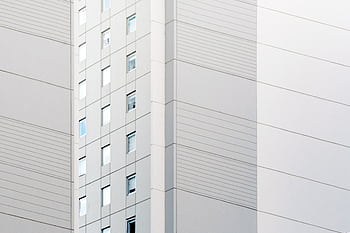 Contemporary building facade showcasing minimalist design with clean lines and glass windows. HD wallpaper