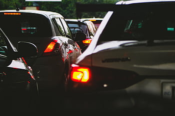 A close-up view of a traffic jam showcasing rear car lights glowing at dusk. HD wallpaper