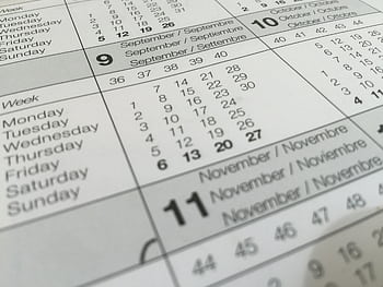 Detailed close-up of a calendar displaying months in several languages. HD wallpaper