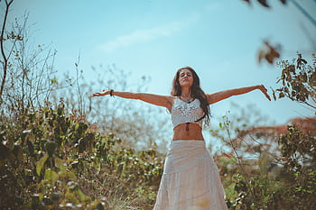 Peaceful scene of a woman meditating outdoors in a sunny summer setting, embodying wellness and tranquility. HD wallpaper