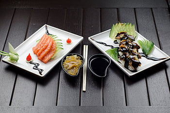 Elegant display of Japanese sushi and sashimi on a dark wood table. HD wallpaper