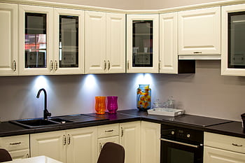 A stylish modern kitchen with white cabinets and colorful decor pieces. HD wallpaper
