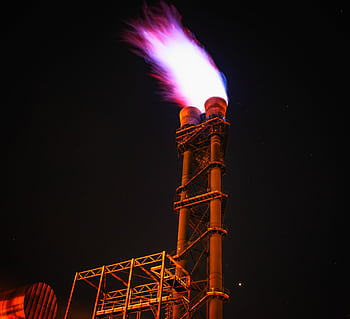 Dramatic night of gas flare on industrial facility emitting a powerful flame. HD wallpaper