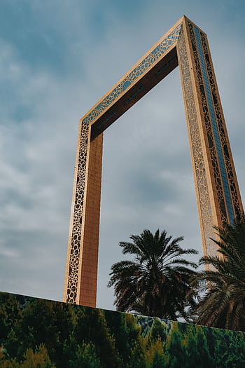 Low angle view of the iconic Dubai Frame against a clear blue sky, showcasing its intricate design. HD phone wallpaper