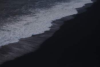 Capture of the striking waves on Vik's iconic black sand beach in Iceland. HD wallpaper