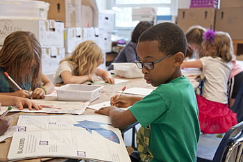 Group of children focused on educational activities in a classroom setting. HD wallpaper