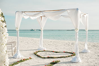 Beautiful beachfront wedding arch with floral decorations on a sunny day in Maldives. HD wallpaper