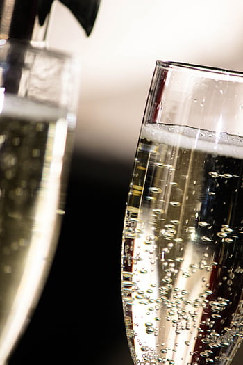 Elegant close-up of champagne bubbles rising in glasses, perfect for celebrations. HD phone wallpaper