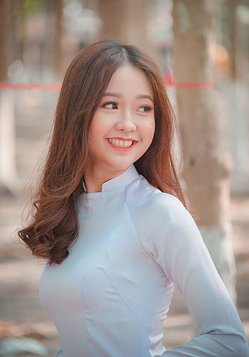A beautiful young woman smiling in a close-up portrait outdoors. HD phone wallpaper