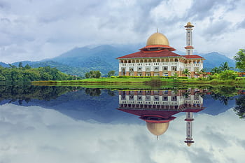 Beautiful mosque reflecting in the lake with a mountainous backdrop in Kuala Kubu Bharu, Malaysia. HD wallpaper