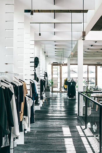 Interior of a contemporary clothing store with stylish apparel and ample natural light. HD phone wallpaper