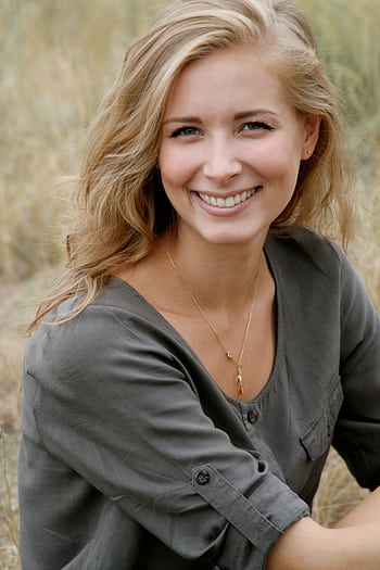 Beautiful portrait of a smiling woman in an outdoor setting, exuding natural beauty and happiness. HD phone wallpaper