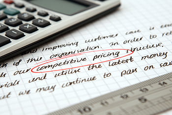 Focused of handwritten business notes with calculator emphasizing pricing strategy. HD wallpaper