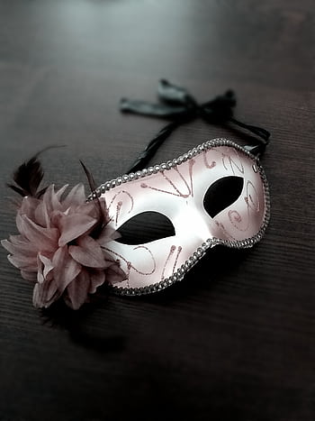 A beautiful Venetian masquerade mask with floral and feather details on a dark wooden table. HD phone wallpaper