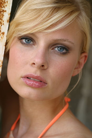 Close-up portrait of a blonde woman with striking blue eyes, exuding elegance and glamour. HD phone wallpaper