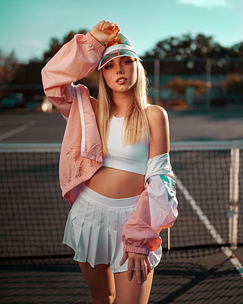 Stylish woman posing on an outdoor tennis court in vibrant sporty attire. HD phone wallpaper