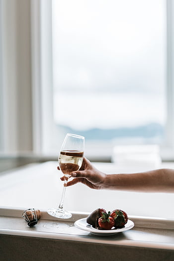 A relaxing indoor setting featuring a wine glass and chocolate-covered strawberries by a window. HD phone wallpaper