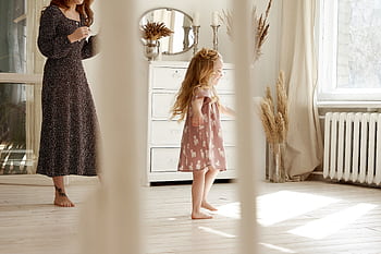 Charming indoor scene of a mother and daughter enjoying a sunny day in a stylish, airy room. HD wallpaper
