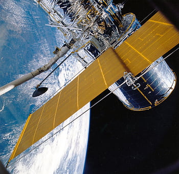 Spacecraft with solar panels orbiting Earth, showcasing modern astronautic technology. HD wallpaper