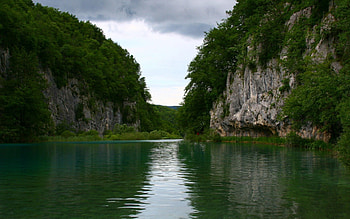 Lake and Large Rocks, blue, large, lake, rock, day, reflection, green, clouds, trees, nature, sky, cliff, water, moutain HD wallpaper