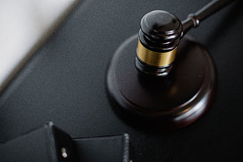 Close-up of a wooden judge's gavel on a black desk, symbolizing justice and law. HD wallpaper