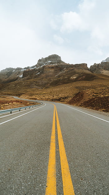 Endless highway with stunning mountain backdrop, perfect for travel and adventure themes. HD phone wallpaper