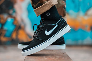 Close-up of black sneakers with camouflage pants, showcasing urban style. HD wallpaper