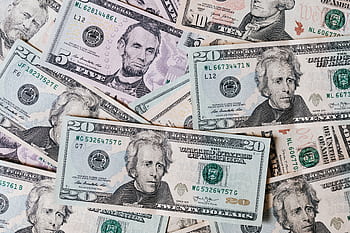 Detailed close-up of scattered US dollar banknotes featuring various denominations. HD wallpaper