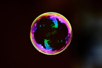 A single colorful soap bubble reflecting hues against a dark background. HD wallpaper