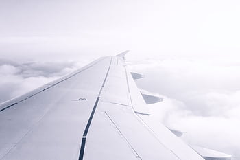 A serene view of an airplane wing flying above the clouds, capturing travel essence HD wallpaper